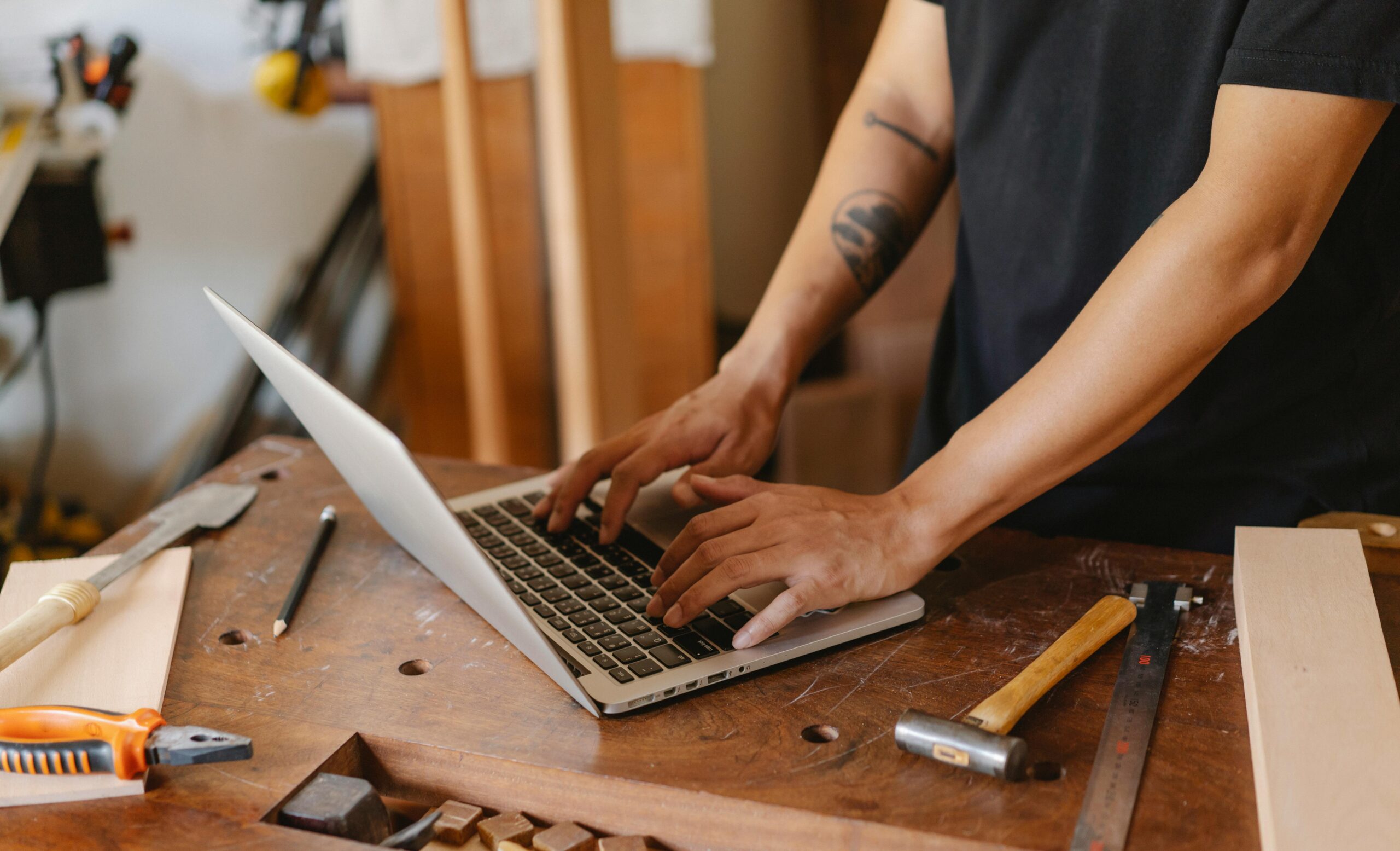 Mann, Der Laptop Auf Holztisch Im Tischlerstudio Verwendet